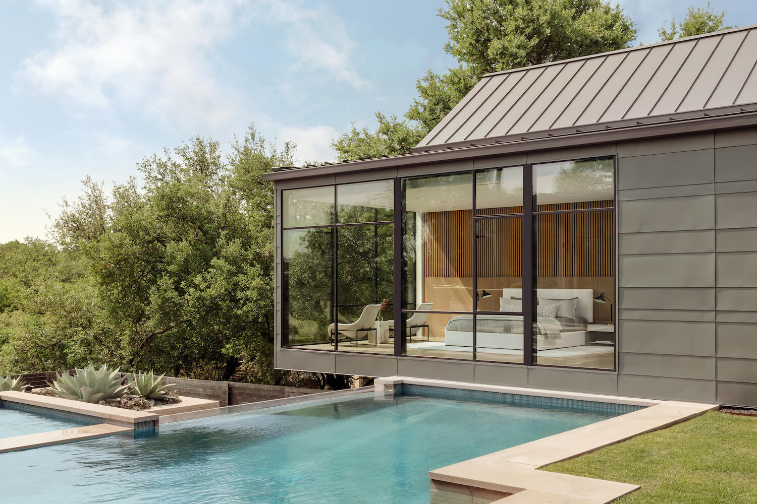 The 10 Most Expensive Neighborhoods in Austin (2026 Guide) Modern Rollingwood, Austin luxury home with standing-seam metal roof, floor-to-ceiling glass, and infinity pool overlooking the Hill Country