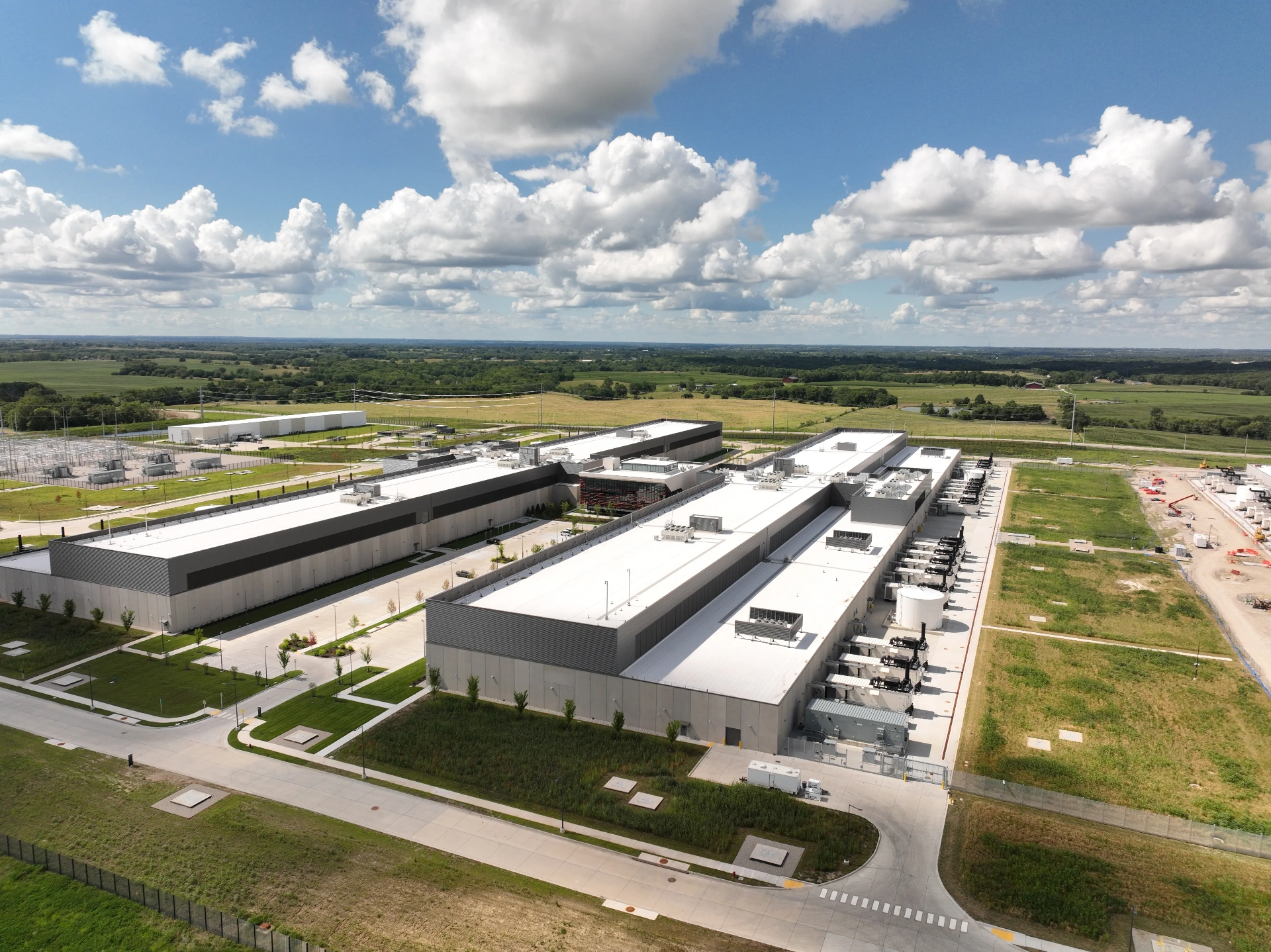 Aerial view of a large hyperscale data center campus with adjacent power substation and open development land, illustrating the scale of Texas data center infrastructure