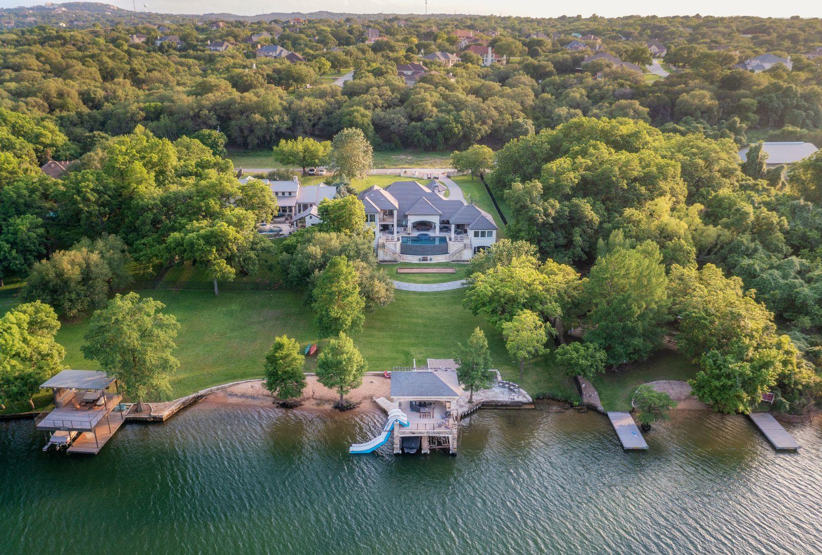 Buy Before You Sell in Austin (2026): Bridge Loans, Texas HELOC Rules, and Keeping Your 3% Mortgage Aerial view of a stone estate on a wooded Austin lakefront lot with a covered boat dock and sweeping lawn
