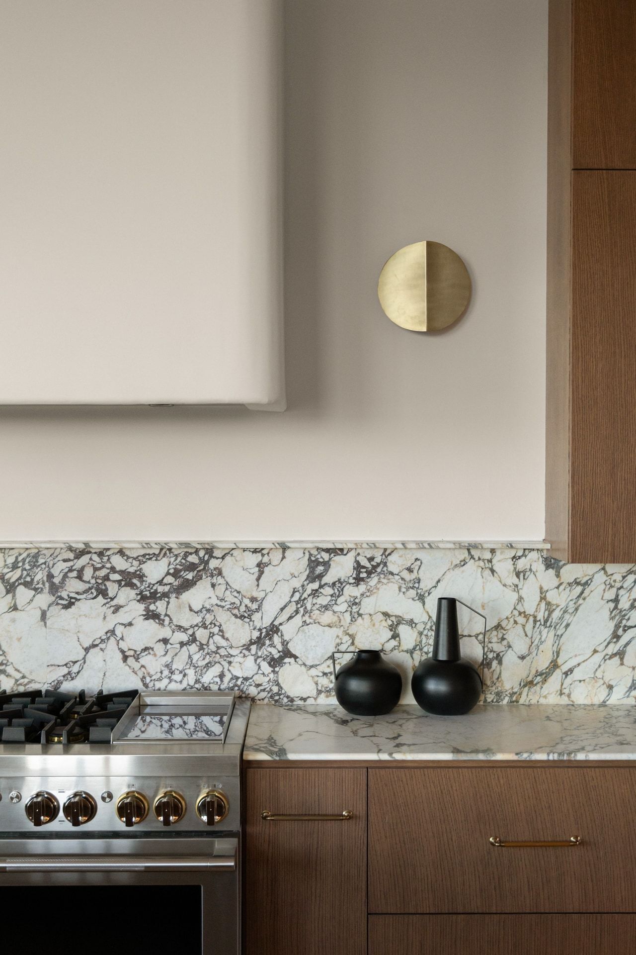 Luxury Austin kitchen with marble backsplash, walnut cabinetry, and brass accents