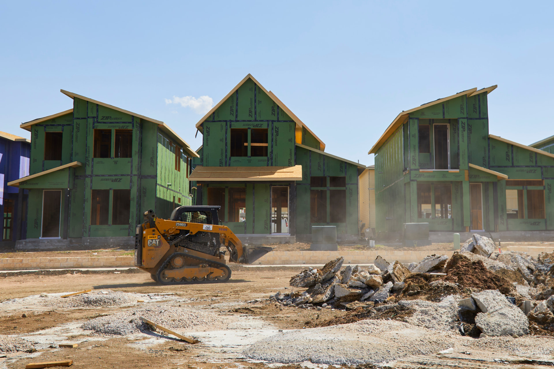 Builder Incentives in Austin, 2026: What the 4.99 Percent Rate Really Costs and What Is Actually Negotiable New Austin-area home under construction at framing stage with limestone masonry, exposed roof framing and rolled blueprints on a stone ledge in the foreground